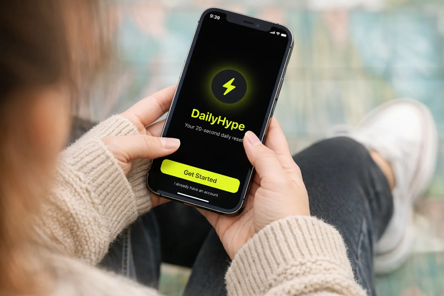 Person hält Telefon mit Daily Hype-App auf dem Bildschirm